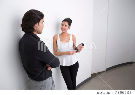 Young businesspeople in corridor talking 7896532