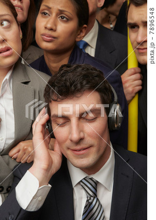 Businesswoman wearing headphones on subway train 7896548