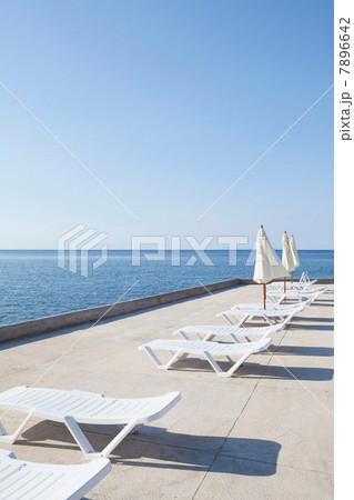 Sun loungers on deck by the ocean 7896642