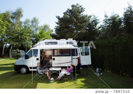 Couple eating breakfast outside campervan 7897310