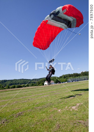Skydiver landing with parachute 7897600