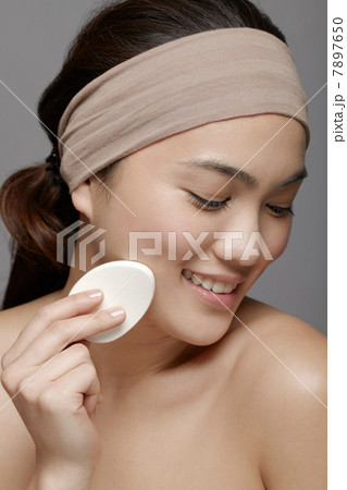 Young woman using make up sponge Young woman using make up sponge 7897650