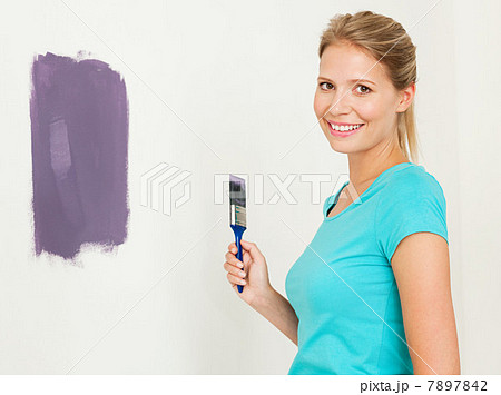 Young woman painting a wall Young woman painting a wall 7897842