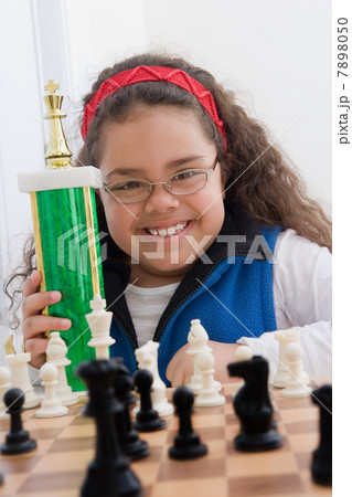 Portrait of young girl holding chess trophy 7898050