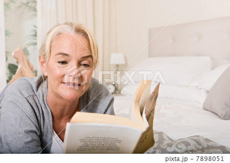 Mature woman reading in bedroom 7898051