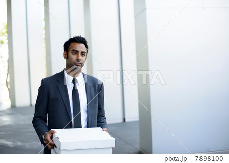 Businessman leaving office with box of personal items 7898100
