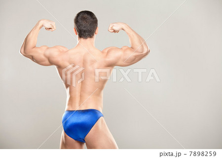 Bodybuilder flexing muscles, rear view Bodybuilder flexing muscles, rear view 7898259