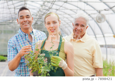 Senior, mature man and mid adult woman in garden centre, portrait Senior, mature man and mid adult woman in garden centre, portrait 7898421