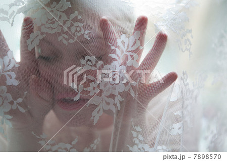 Young woman behind lace curtain Young woman behind lace curtain 7898570