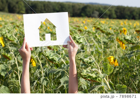 Woman holding card with house shape 7898671