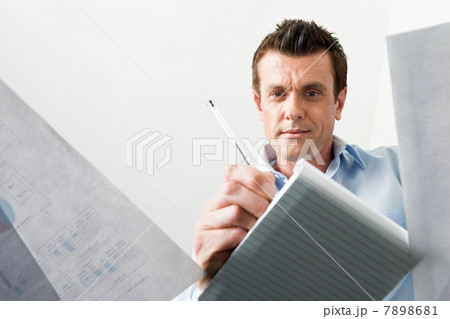 Business man writing in a notebook Business man writing in a notebook 7898681