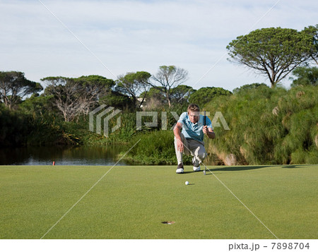 Man playing golf, on putting green Man playing golf, on putting green 7898704