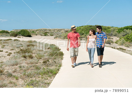 Young friends walking down rural road Young friends walking down rural road 7899051