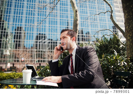 Businessman on cellphone outdoors 7899301