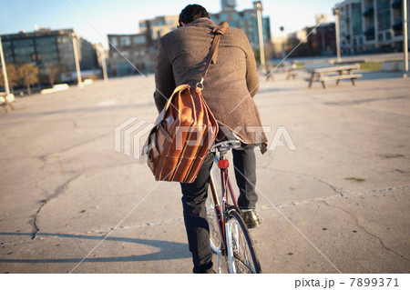 Man riding bicycle on city street 7899371