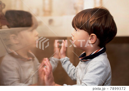 Portrait of male toddler looking at his reflection Portrait of male toddler looking at his reflection 7899372
