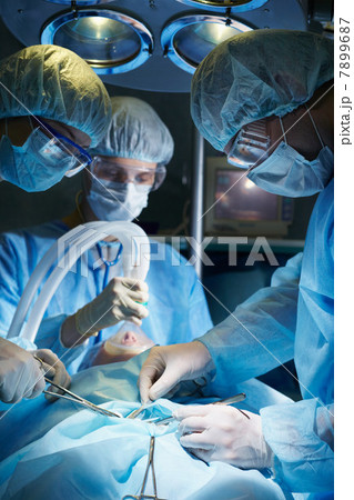 Surgeons operating on a patient 7899687