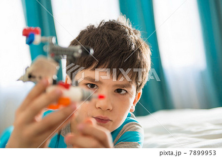 Boy playing with toy in bedroom Boy playing with toy in bedroom 7899953