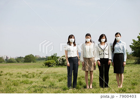 Businesswoman wearing pollution masks in field 7900403
