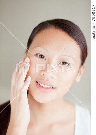 Woman moisturizing her face 7900517