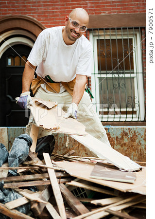 Man filling skip with rubble Man filling skip with rubble 7900571