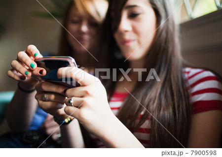 Two teenage girls using smartphone 7900598