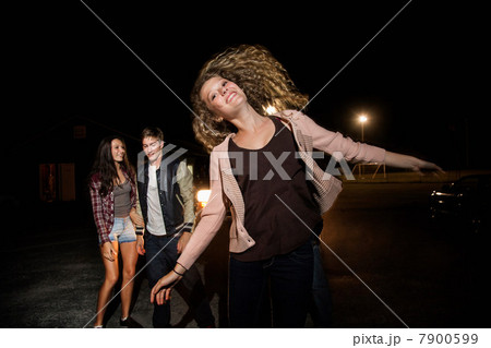 Three friends in parking lot at night 7900599