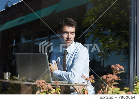 Businessman in cafe, view through window Businessman in cafe, view through window 7900664