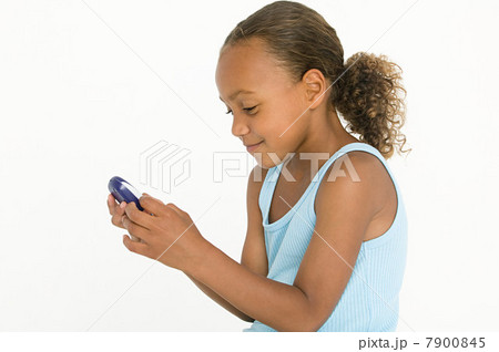 Girl playing on hand-held device Girl playing on hand-held device 7900845