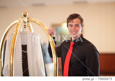 Porter with luggage cart in hotel lobby 7900875