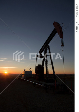 Silhouette of oil well in dry landscape Silhouette of oil well in dry landscape 7901102