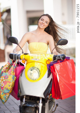 Woman carrying shopping bags on scooter Woman carrying shopping bags on scooter 7901155