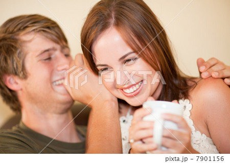 Man whispering in girlfriend's ear Man whispering in girlfriend's ear 7901156