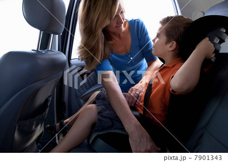 Mother fastening child safety seat belt in car Mother fastening child safety seat belt in car 7901343