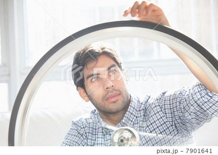 Man fixing bicycle wheel indoors 7901641