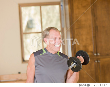Older man lifting weights at home Older man lifting weights at home 7901747