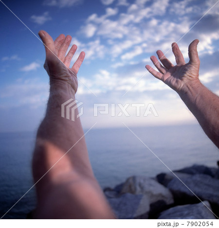 Close up of man with arms stretched in yoga pose by the ocean Close up of man with arms stretched in yoga pose by the ocean 7902054