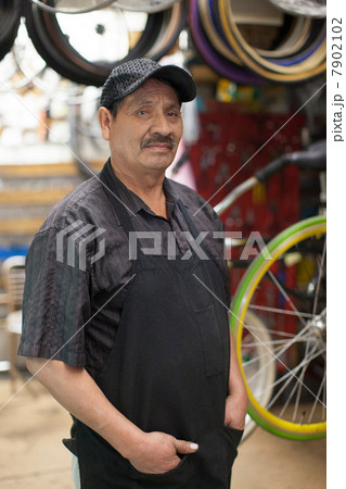 Mechanic standing in bicycle shop Mechanic standing in bicycle shop 7902102