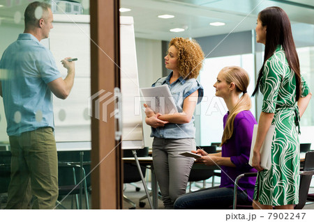 Office colleagues in whiteboard meeting in office Office colleagues in whiteboard meeting in office 7902247