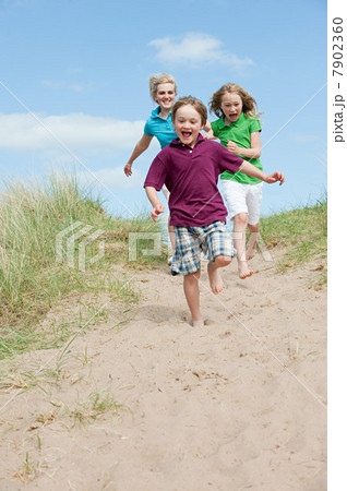 Brother and sisters running to the beach 7902360