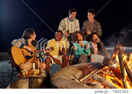 Friends having beach party at night 7902362