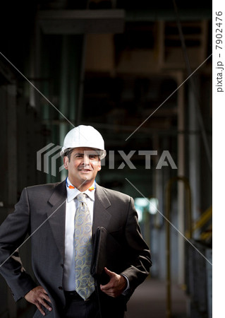Businessman carrying folder in plant 7902476