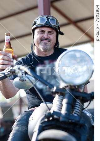 Man drinking beer on motorcycle 7902904