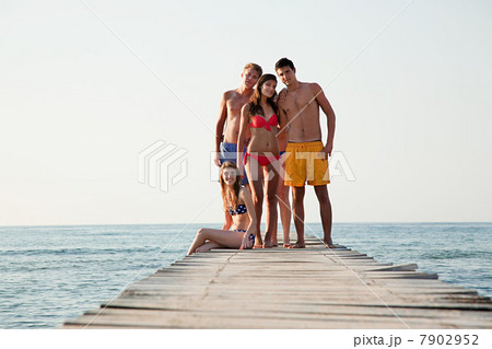 Young friends standing on jetty Young friends standing on jetty 7902952
