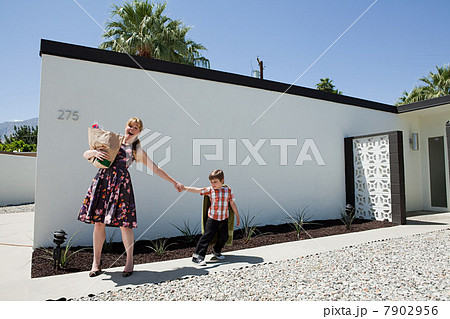 Mother holding shopping bag and pulling son's arm 7902956
