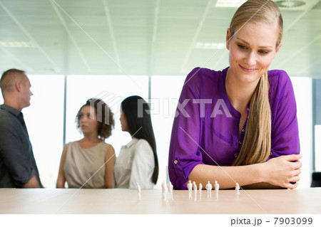 Young architect sitting at desk with model figures 7903099