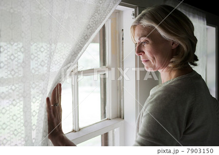 Mature woman looking out of window 7903150