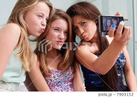 Teenage girls taking a picture of themselves making faces Teenage girls taking a picture of themselves making faces 7903152