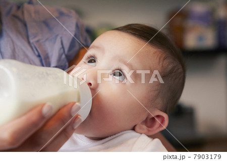 Baby girl drinking bottle of milk 7903179
