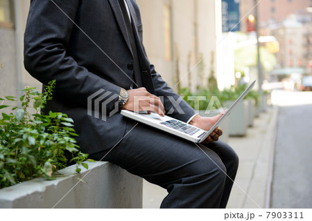 Businessman using laptop outdoors 7903311